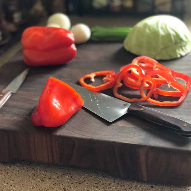 Chef knife cutting vegetables on a cutting board